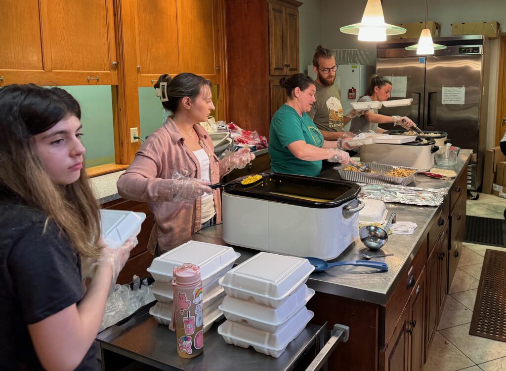 Workers packing take outs for April community dinner.